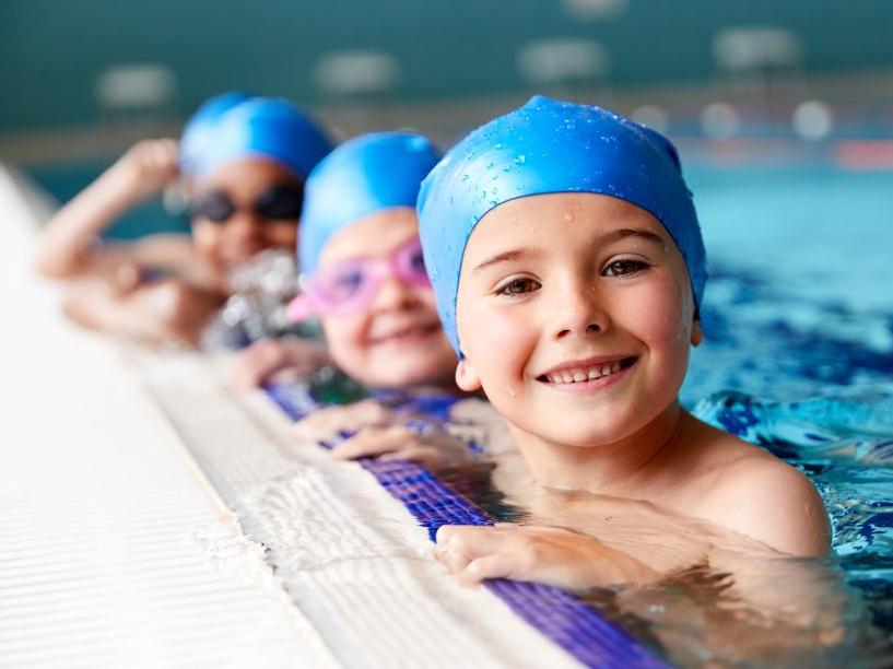 Kids in the pool in swimming caps
